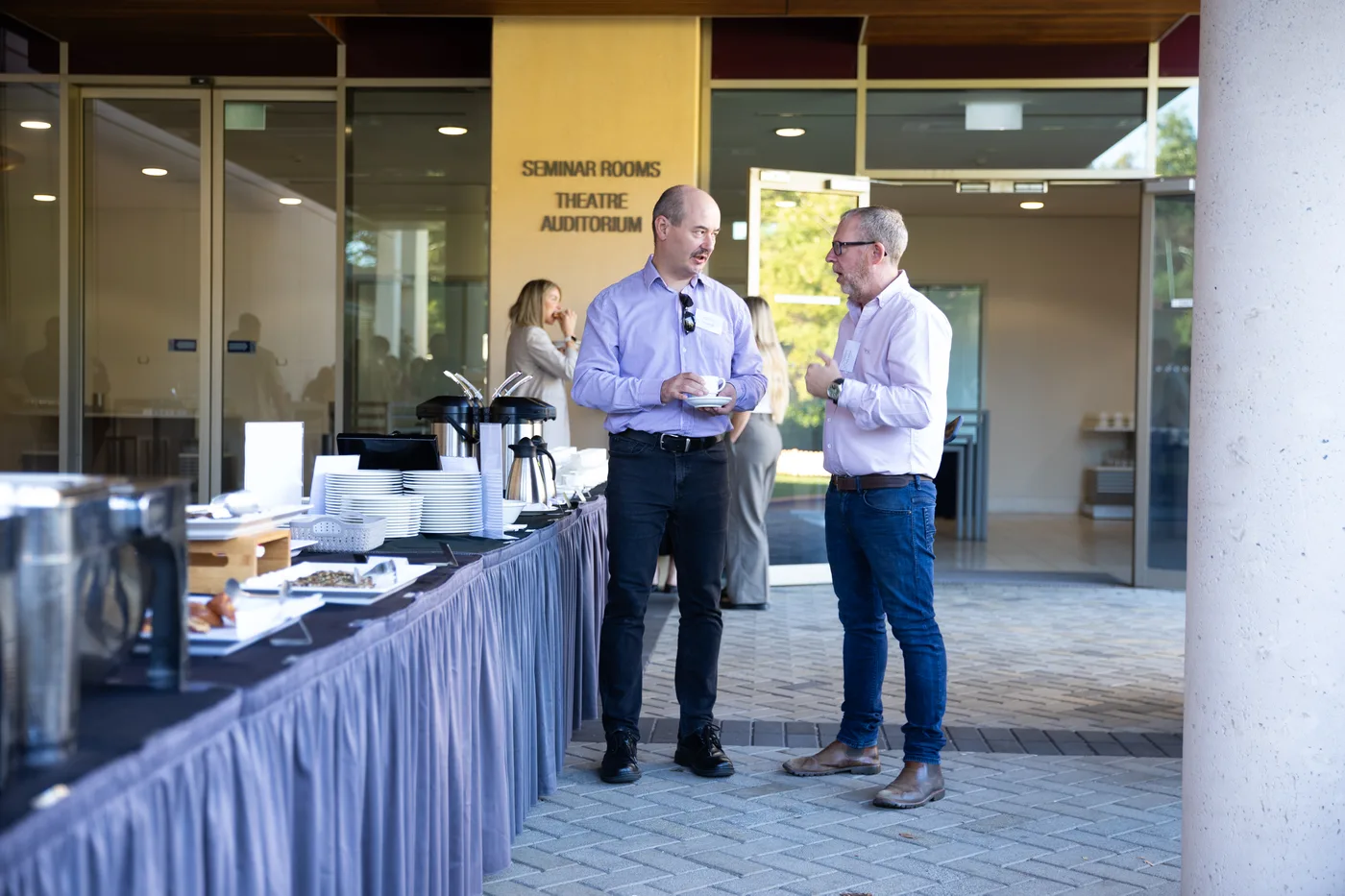 Two executives in conversation at a leadership event